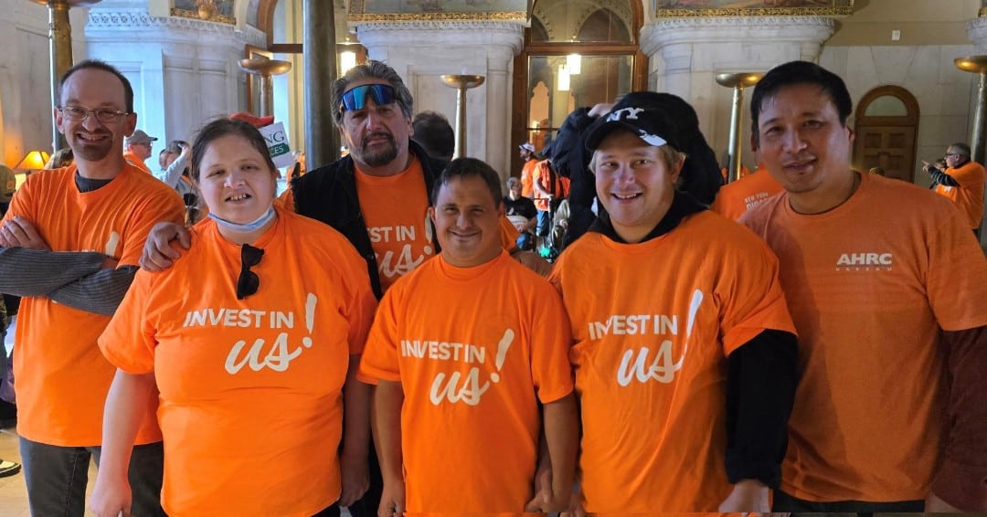 Self-advocates wear shirts that read "Invest in us!"