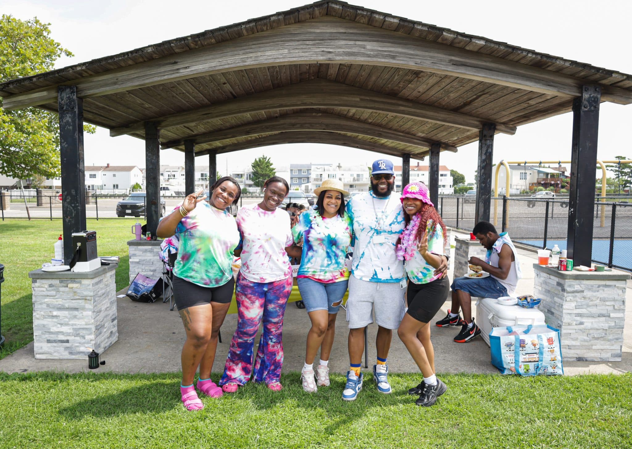 TFive staff members stand next to each other at the barbecue.