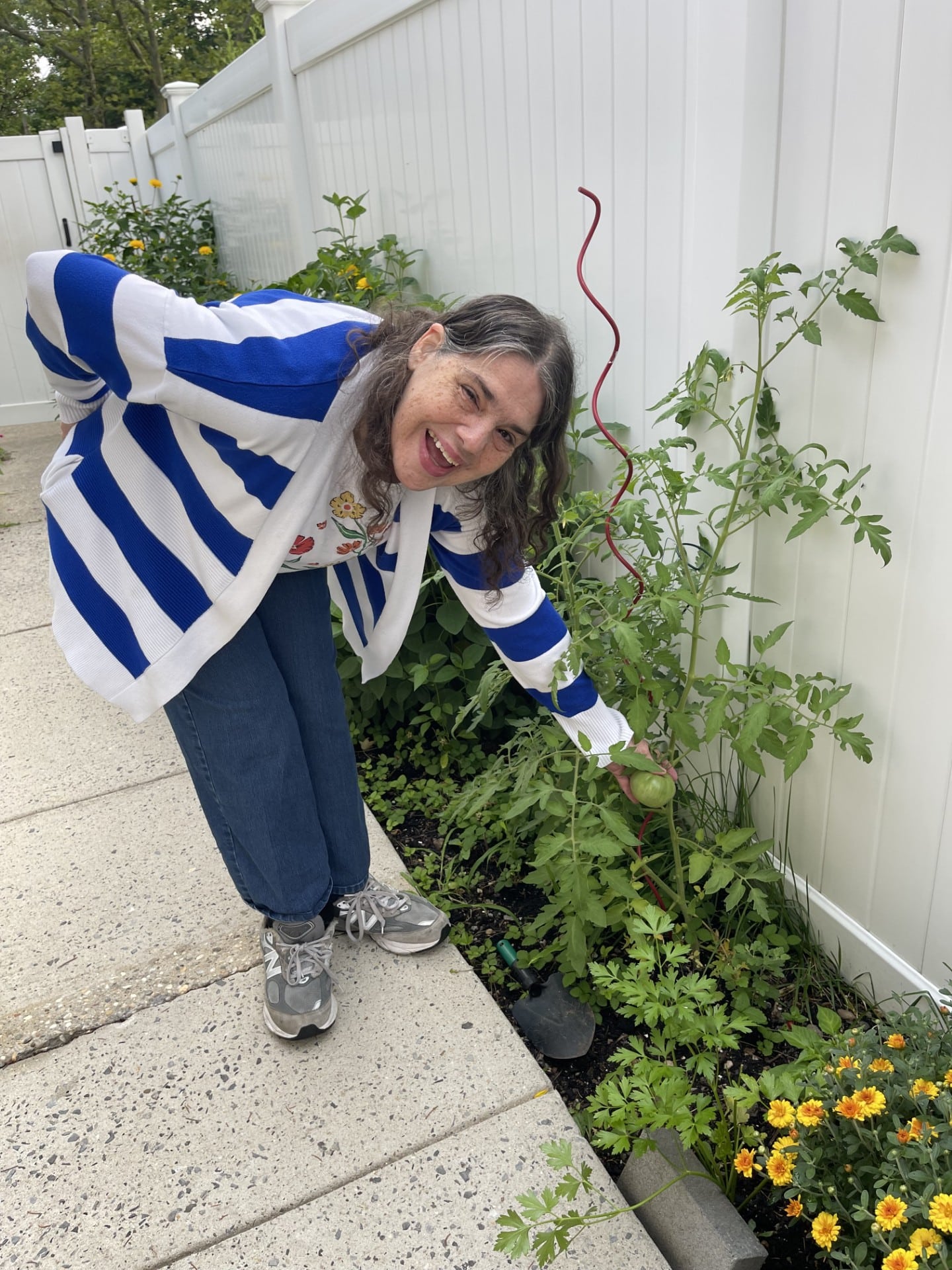 An Elmwood Lane resident holds a tomato in the garden