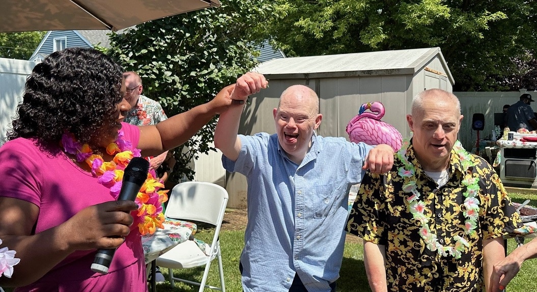 Residents and staff members dance at the tropical-themed summer party