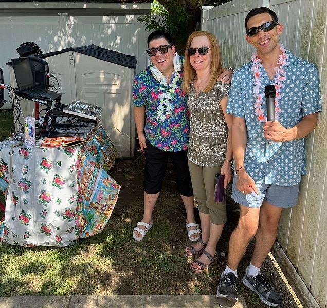 DJ Jumpin Johnny G and staff members enjoy the tropical-themed summer party