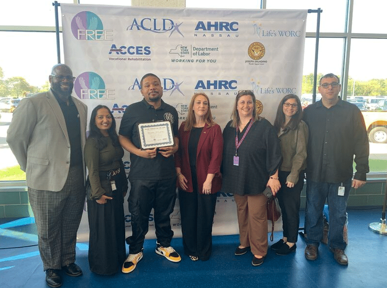 Seven attendees of the job expo in front of a step and repeat